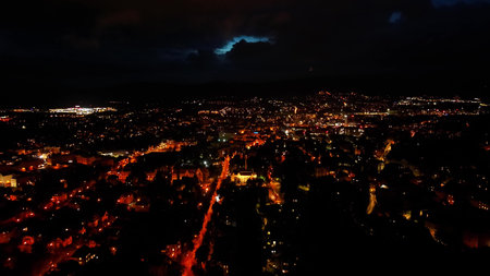 A breathtaking aerial view captured at night time of a bustling city, revealing vibrant lights and urban landscapesの写真素材