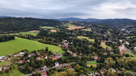 An aerial shot captures the breathtaking view of green fields and quaint homes in a picturesque...
