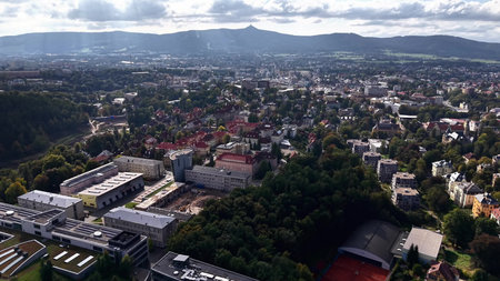 A breathtaking aerial view showcases a vibrant city beautifully nestled amidst lush green mountains...