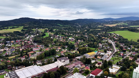 Stunning aerial view capturing the charm of a picturesque village tucked away in lush hills and vibrant green fieldsの写真素材