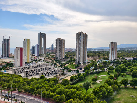 A vibrant cityscape that showcases contemporary skyscrapers beautifully positioned amidst lush greenery all aroundの写真素材