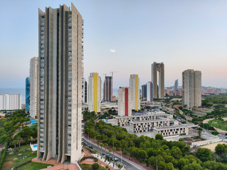 A breathtaking and stunning view of modern skyscrapers lining the picturesque coastline during a vibrant sunsetの写真素材