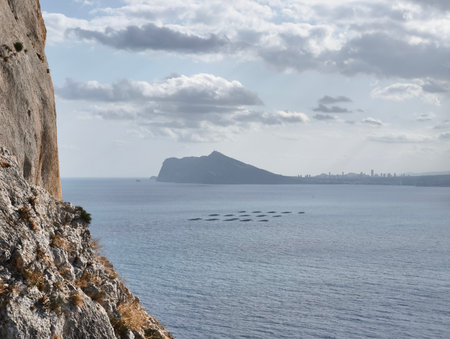 The breathtaking coastal view showcases a stunning mountain silhouette perfectly framed by the serene watersの写真素材