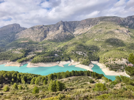 The stunning landscape has a shimmering turquoise lake surrounded by majestic mountains in the backgroundの写真素材