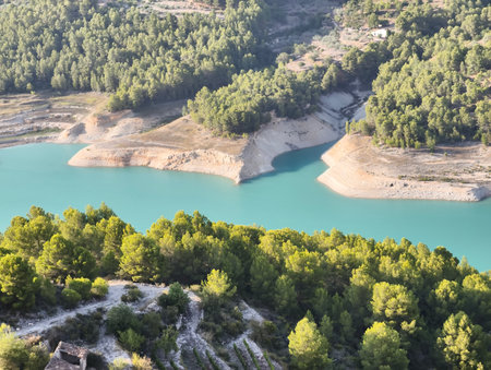 The breathtaking scenery features a stunning turquoise lake beautifully nestled among vibrant, lush treesの写真素材