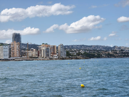 A breathtaking seaside view showcasing a coastal city skyline against the blue sky and ocean beyondの写真素材
