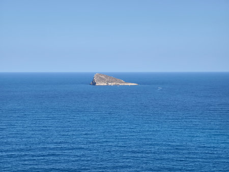 A serene and beautiful view of a picturesque small island that is surrounded by the clear blue waters of the vast oceanの写真素材