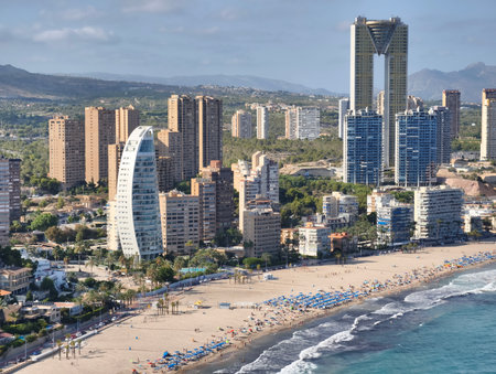 The stunning seaside skyline beautifully showcases impressive contemporary architecture amidst vibrant beach lifeの写真素材