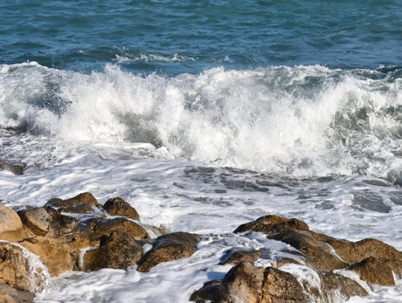 Majestic ocean waves crash against rugged rocks, showcasing the immense power of nature in a breathtaking sceneの写真素材