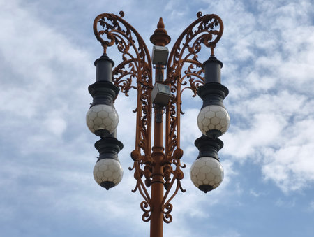 This beautifully designed vintage street lamp showcases intricate ornate details combined with bright, shining globesの写真素材