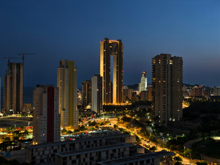 A stunning city skyline at dusk, beautifully showcasing illuminated towers and vibrant streets filled with lifeの写真素材