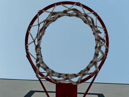 A truly striking view of a basketball hoop paired with a magnificent clear blue sky in the...