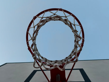 This image offers a unique view of a basketball hoop against a clear blue sky, ideal for sportsthemed projectsの写真素材