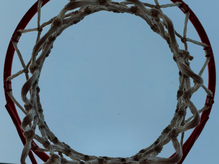 Capture the vibrant essence and excitement of basketball with a unique and creative view through the hoopの写真素材