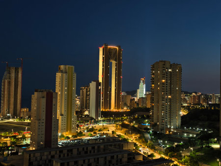 A stunning view of a city skyline at night, showcasing tall buildings illuminated against the dark sky.の写真素材