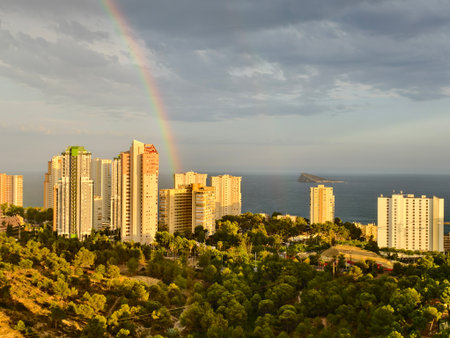 vibrant cityscape scene, colorful skyline near sea, sunset over city with rainbow and sea viewの写真素材