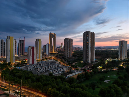 silent city skyline under moody sky, tranquil night scene with illuminated towers and distant lightsの写真素材