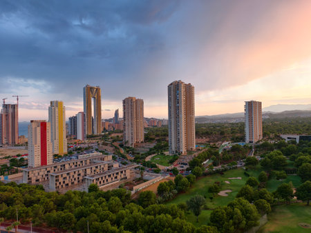 coastal sunset bathes urban landscape, romantic sunset highlighting city towers and lushの写真素材
