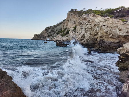 scenario simulating powerful water and spray impacts on jagged coastal rocks for safety teamsの写真素材