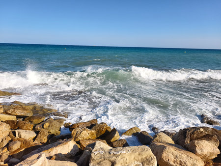 sea wave imagery, coastal waves and rocks scene, foamy surf crashing on rugged coastal stonesの写真素材