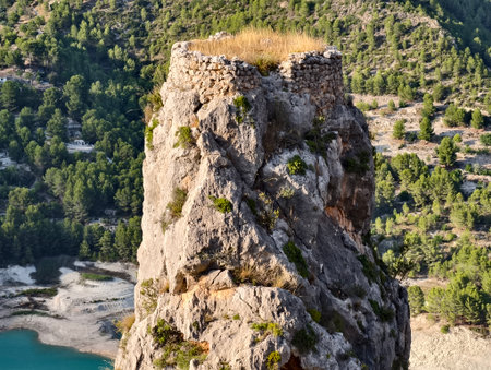clifftop grasstopped pinnacle overlooking river, dramatic rocky summit above winding river and pineの写真素材