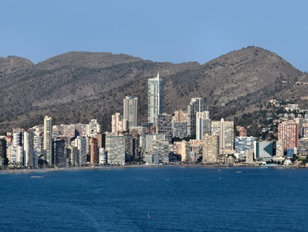 sunlit coastal scene, busy seaside with skyscrapers, vibrant beachfront with boats and buildingsの写真素材