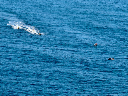 speedboats darting across blue waters at midday, speedboats racing with twin wakes under brightの写真素材