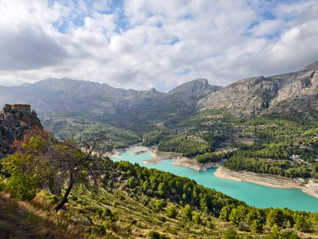 turquoise lake seen from rocky viewpoint, turquoise reservoir observed from rugged outcropの写真素材