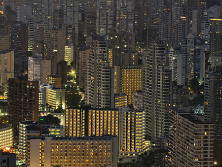 night cityscape with illuminated buildings, bright metropolis featuring glowing windows and denseの写真素材