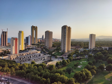 urban oasis at sunset, aerial view of peaceful urban park surrounded by modern buildings and treesの写真素材