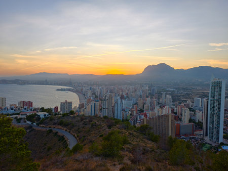 breathtaking golden hour view showcasing mixed residential towers along curved bay with mountainの写真素材