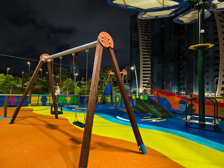 quiet city shadows, deserted playground with glowing slide and contrasting shadows under moodyの写真素材