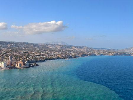 picturesque curved bay with sparkling turquoise waters and surrounding hotels and promenadesの写真素材