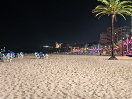 calm seaside evening, peaceful beach setting reflecting calmness of city night illuminated by gentleの写真素材