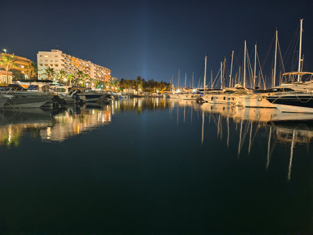 yacht reflections in calm harbor, peaceful harbor scene with serene reflections and glowing lightsの写真素材