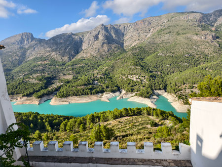 balcony terrace provides breathtaking views of vibrant turquoise waters and rugged mountain summitsの写真素材