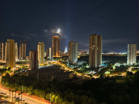 quiet city streets bathed in soft moonlight, calm urban night scene with glowing moon and distantの写真素材