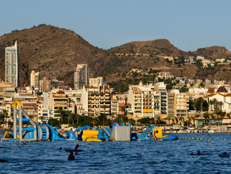 sunny water adventure at beach, family and friends enjoy lively floating obstacle courseの写真素材