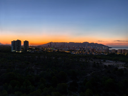 colored horizon highlights city skyline tranquility, dusk paints skyline with warm glow and calmの写真素材