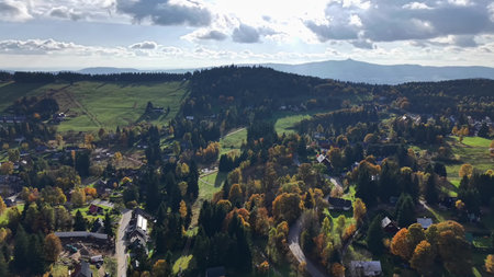 aerial perspective showcasing rural community with vibrant fall hues and undulating terrain