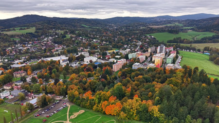 colorful buildings surrounded by nature, bright apartment complexes amid seasonal trees and hillyの写真素材