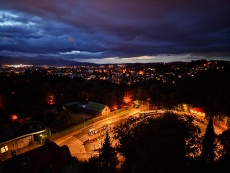 Curving Highway Lit By Headlights, River Of Traffic Lines And Glowing Barriers, Suburban Rooftops Framingの写真素材