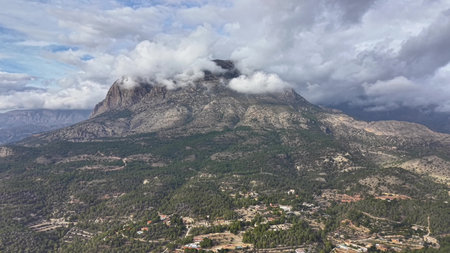 cloud capped summit under storm clouds, dramatic granite cliffs shrouded in mist, moody light and turbulentの写真素材