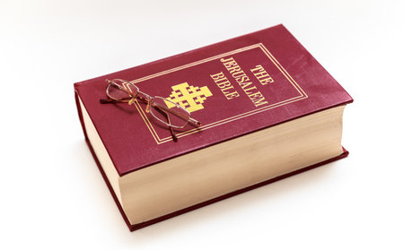 red Bible book with reading glasess on top