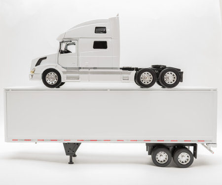Closeup view of transport truck standing on top of the trailer isolated on white, grayish backgroundの写真素材
