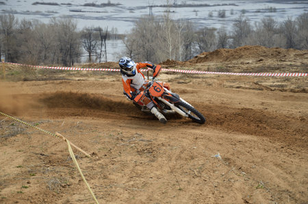 Motorbike racer turns sharply to the on a sandy track a motocross practice