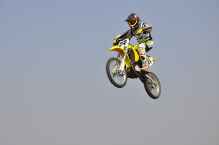 Motocross motorbike racer performs a jump efficient, hangs in the open airの写真素材