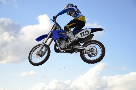 RUSSIA, SAMARA, CHAPAYEVSK - OCTOBER 17: High flight of motorcycle racer V. Kulakov on a motorcycle on the background of clouds the Open Cup "Volga" motocross on October 17, 2011 in Chapayevsk, Samara, Russiaのeditorial素材