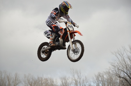 RUSSIA, SAMARA, CHAPAYEVSK - OCTOBER 17: High flight of motorcycle racer E. Pershin on the background of clouds the Open Cup "Volga" motocross on October 17, 2011 in Chapayevsk, Samara, Russiaのeditorial素材