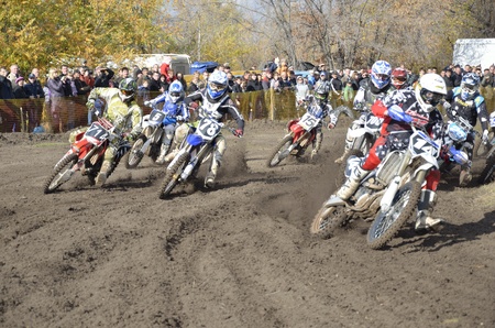 RUSSIA, SAMARA, CHAPAYEVSK - OCTOBER 17: Start, a group of motorbike racing in the MX2 class competition in the first corner the Open Cup "Volga" motocross on October 17, 2011 in Chapayevsk, Samara, Russiaのeditorial素材